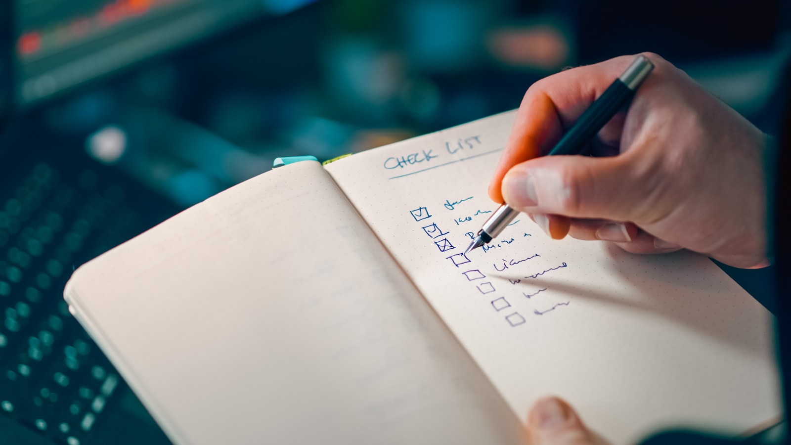 Ręka zapisująca checklistę w notatniku